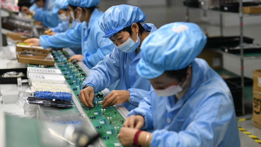 Employees work on a circuit board production line at the workshop of Anhui Shixin Electronic Technology Co LTD in Fuyang, China.