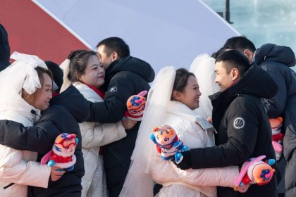 Couples hug each other during a group wedding at the Harbin Ice-Snow World in Harbin, northeast China's Heilongjiang Province on January 6, 2025.