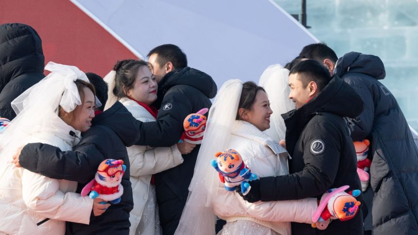 Couples hug each other during a group wedding at the Harbin Ice-Snow World in Harbin, northeast China's Heilongjiang Province on January 6, 2025.