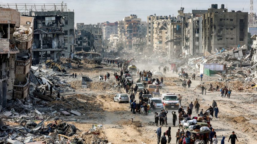 People walk past the rubble of collapsed buildings along Saftawi street in Jabalia in the northern Gaza Strip on January 20.