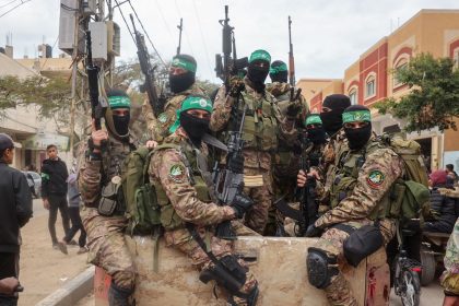 Hamas fighters patrol a street before they handover three Israeli hostages to a Red Cross team in Deir el-Balah, central Gaza, on February 8.