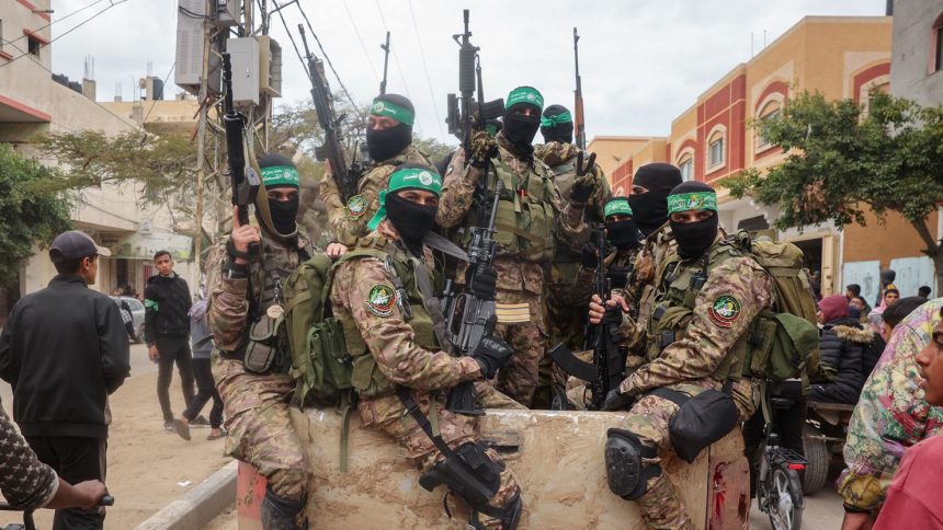 Hamas fighters patrol a street before they handover three Israeli hostages to a Red Cross team in Deir el-Balah, central Gaza, on February 8.