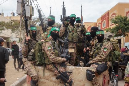 Hamas fighters patrol a street before the handover of three Israeli hostages to a Red Cross team in Deir el-Balah, Gaza, on Saturday.