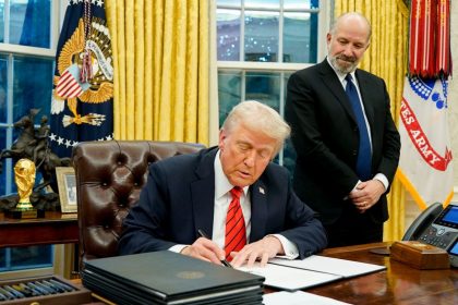 President Donald Trump signs executive actions in the Oval Office on Feb. 10, 2025.