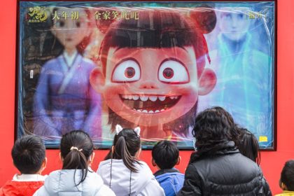 People look at a promotional video for Chinese animated blockbuster 'Ne Zha 2' in Chengdu, China's Sichuan province, on February 10, 2025.