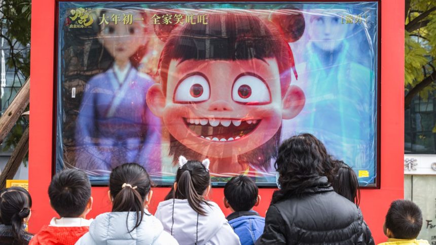 People look at a promotional video for Chinese animated blockbuster 'Ne Zha 2' in Chengdu, China's Sichuan province, on February 10, 2025.