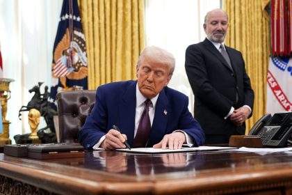 President Donald Trump signs a memo on reciprocal tariffs in the Oval Office at the White House on February 13.