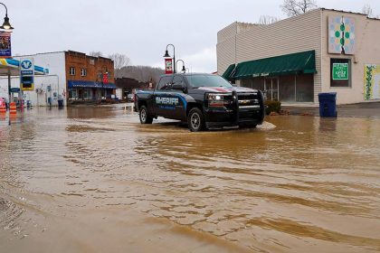 A Lee County sheriff's truck drives through floodwaters Sunday in downtown Beattyville, Kentucky.