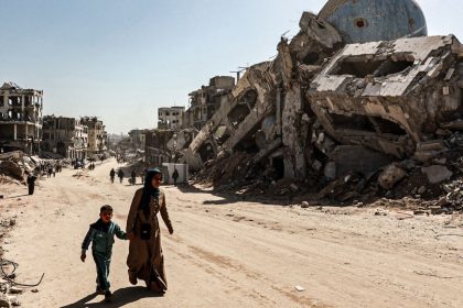 Palestinians among the rubble of buildings destroyed by Israeli attacks in Beit Lahia city in the northern Gaza Strip on February 18, 2025.