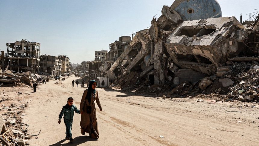 Palestinians among the rubble of buildings destroyed by Israeli attacks in Beit Lahia city in the northern Gaza Strip on February 18, 2025.