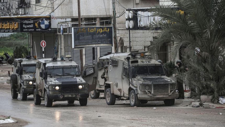 Israeli soldiers block a road during a visit by Israeli Prime Minister Netanyahu to Tulkarm in the occupied West Bank, on February 21.