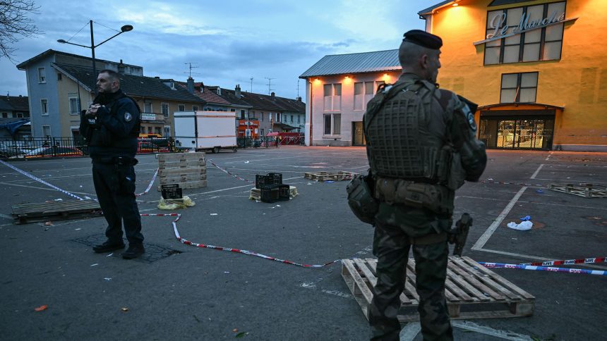 A police officer and a military stand guard at the site of a bladed weapon attack where a man is suspected of killing one person and wounding two municipal police officers in Mulhouse, eastern France on February 22, 2025.