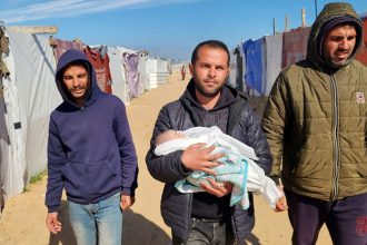 KHAN YUNIS, GAZA - FEBRUARY 25: (EDITOR'S NOTE: Image depicts death) Relatives of the 2-month-old baby Shem Al Shambari, who died of extreme cold in the makeshift tent where he stayed with his family, carry his dead body to the cemetery before burying him in Khan Yunis, Gaza on February 25, 2025. Five newborn babies froze to death in the Gaza Strip amid cold weather in the war-torn enclave, a Palestinian doctor said on Tuesday. "Nine infants were hospitalized in the past two weeks due to health complications caused by severe cold," Saeed Salah, Director of the Patient's Friends Benevolent Society Hospital in Gaza, told Anadolu. (Photo by Hani Alshaer/Anadolu via Getty Images)