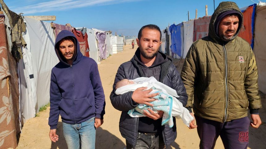 KHAN YUNIS, GAZA - FEBRUARY 25: (EDITOR'S NOTE: Image depicts death) Relatives of the 2-month-old baby Shem Al Shambari, who died of extreme cold in the makeshift tent where he stayed with his family, carry his dead body to the cemetery before burying him in Khan Yunis, Gaza on February 25, 2025. Five newborn babies froze to death in the Gaza Strip amid cold weather in the war-torn enclave, a Palestinian doctor said on Tuesday. "Nine infants were hospitalized in the past two weeks due to health complications caused by severe cold," Saeed Salah, Director of the Patient's Friends Benevolent Society Hospital in Gaza, told Anadolu. (Photo by Hani Alshaer/Anadolu via Getty Images)