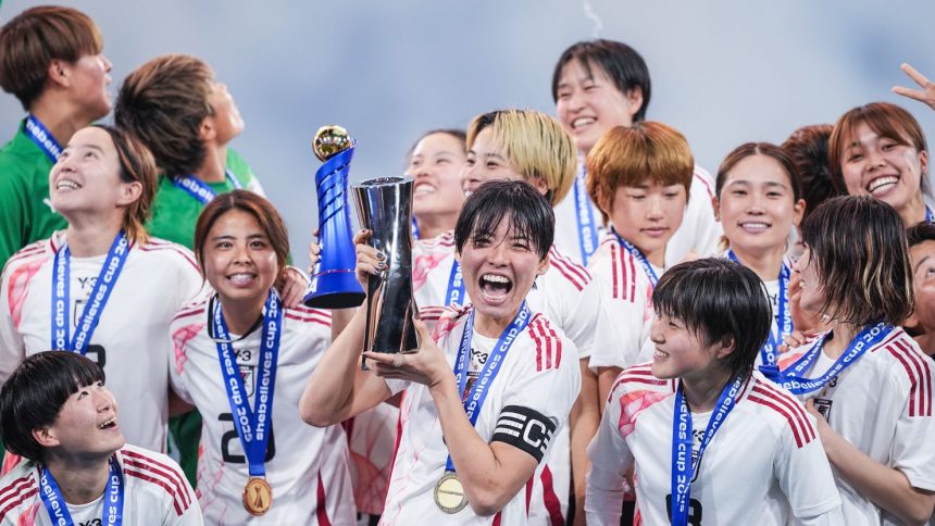 Japan's Saki Kumagai holds the SheBelieves Cup trophy after victory against the US.