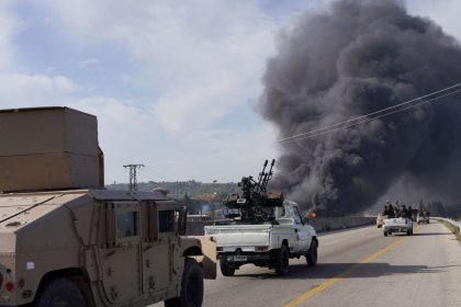 Syrian armed forces drive toward rising smoke as they battle pro-Bashar al-Assad fighters in Latakia, Syria, on Friday.