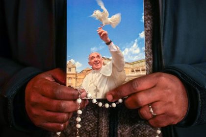 A priest holds a photograph of Pope Francis during the nightly Rosary prayer service in St. Peter's Square on March 6.