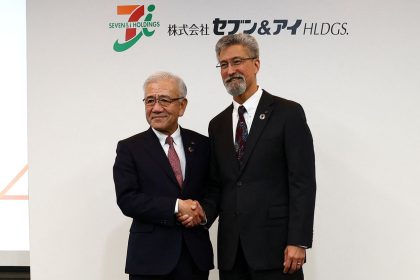 Outgoing Seven & I Holdings CEO Ryuichi Isaka (left) shakes hands with incoming CEO Stephen Dacus (right) at a press conference in Tokyo.