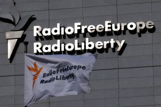 A flag and a sign of Radio Free Europe/Radio Liberty.