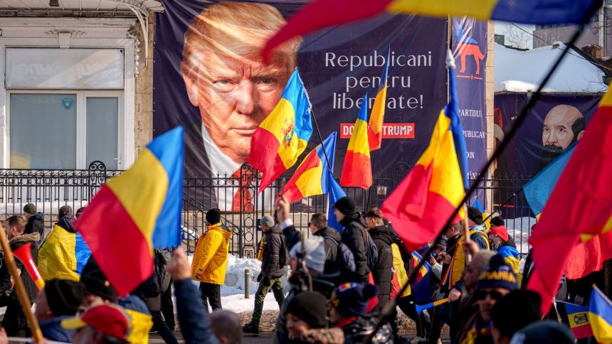 Supporters of Calin Georgescu march past a banner of Donald Trump reading "Republicans for Freedom" in Bucharest, Romania, February 22, 2025.