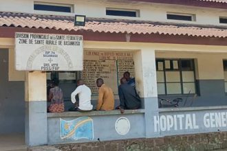 Men sit outside the general hospital in Basankusu, Democratic Republic of the Congo, where some victims of unidentified illnesses are being treated on February 27, 2025.