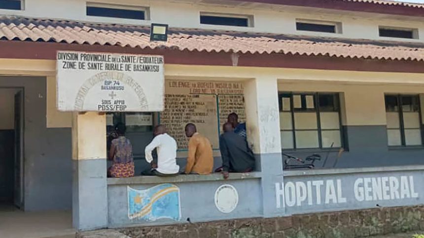 Men sit outside the general hospital in Basankusu, Democratic Republic of the Congo, where some victims of unidentified illnesses are being treated on February 27, 2025.