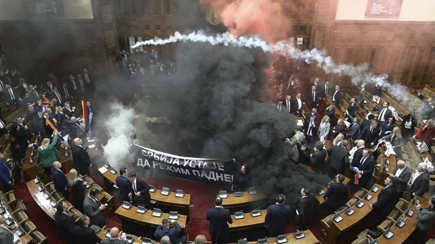 In this screen grab, taken from video provided by RTS Serbia, smoke bombs and flares are seen inside parliament, in Belgrade, Serbia on Tuesday.