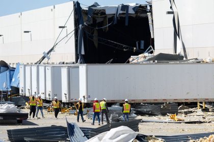 A workers walk outside a damaged warehouse after storms moved through March 4 in Lewisville, Texas. (AP Photo/LM Otero)