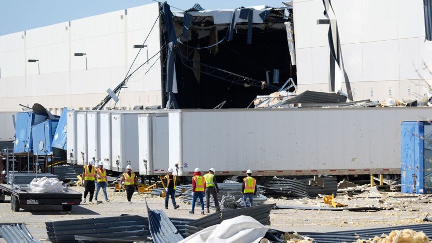 A workers walk outside a damaged warehouse after storms moved through March 4 in Lewisville, Texas. (AP Photo/LM Otero)