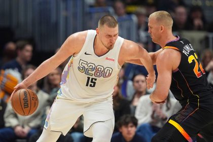 Nikola Jokić, left, drives to the basket against Phoenix Suns center Mason Plumlee during their game on Friday.