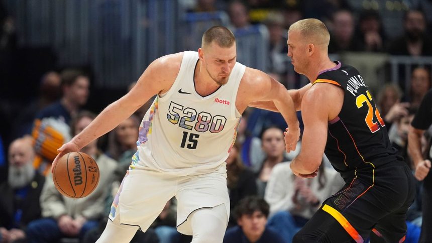 Nikola Jokić, left, drives to the basket against Phoenix Suns center Mason Plumlee during their game on Friday.