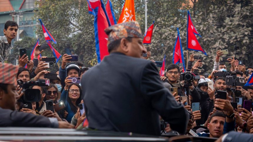 Former King Gyanendra Shah of Nepal waves upon his arrival at Tribhuvan International Airport in Kathmandu, Nepal, on Sunday, March 9, 2025.