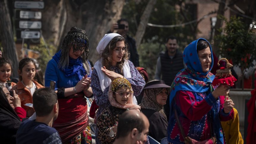 An Iranian woman wears traditional dresses and performs with a wooden goat doll, a symbol of the arrival of spring, in a ceremony to welcome the Iranian New Year outside the Cinema Museum in northern Tehran, Iran, on March 14, 2025. (Photo by Morteza Nikoubazl/NurPhoto via AP)