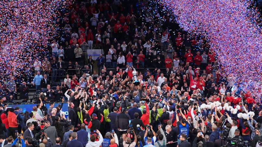 St. John's Zuby Ejiofor holds celebrates with teammates while holding the tournament trophy after an NCAA college basketball game against Creighton in the championship of the Big East Conference tournament.