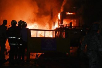 Policemen watch as vehicles are torched during clashes sparked by protests demanding the removal of the tomb of 17th-century Muslim Mughal ruler Aurangzeb, in Nagpur, India, on Monday, March 17, 2025.