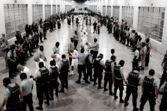 Salvadoran police officers escort alleged members of the Venezuelan Tren de Aragua gang recently deported by the US to the Terrorism Confinement Center (CECOT) prison in Tecoluca, El Salvador.