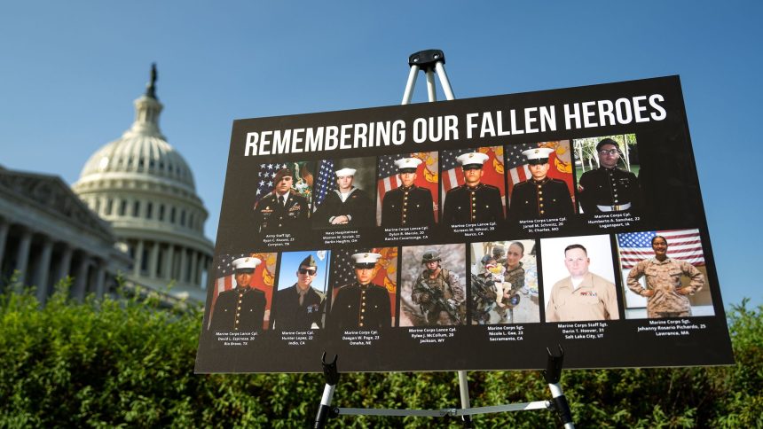 A sign displaying photos and names of the 13 service members killed in a terrorist attack at Abbey Gate outside Kabul's Hamid Karzai International Airport is seen during a news conference at the U.S. Capitol on September 9, 2024 in Washington, DC.