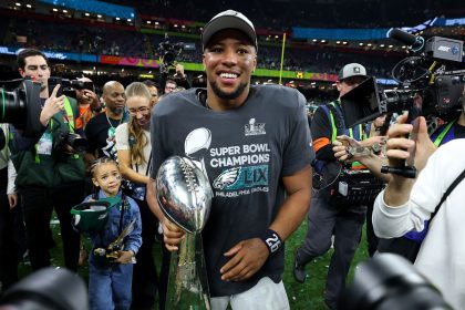 Saquon Barkley celebrates with the Vince Lombardi Trophy after beating the Kansas City Chiefs at Super Bowl LIX.