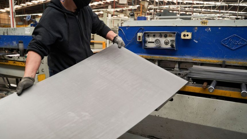 A worker feeds sheet aluminum into a machine at an auto parts manufacturer in San Luis Potosi, San Luis Potosi state, Mexico, on Monday, Feb. 17, 2025.