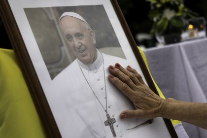 A woman touches a portrait of Pope Francis on February 24, 2025, in Buenos Aires, Argentina.