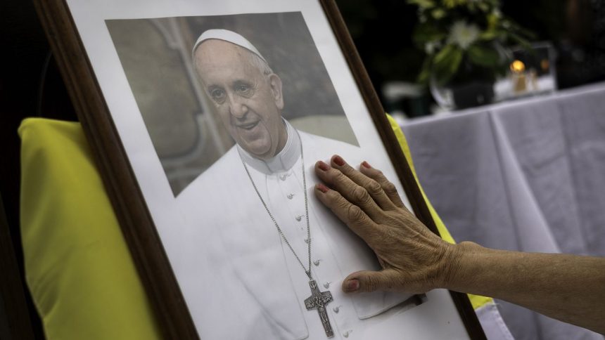 A woman touches a portrait of Pope Francis on February 24, 2025, in Buenos Aires, Argentina.