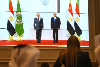 People watch on a big screen as Egypt's President Abdel Fattah al-Sisi, right, welcomes Jodran's King Abdullah II ahead of an Arab League summit in Cairo, Egypt, on Tuesday.