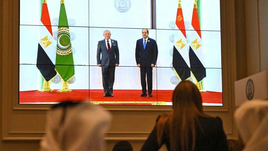 People watch on a big screen as Egypt's President Abdel Fattah al-Sisi, right, welcomes Jodran's King Abdullah II ahead of an Arab League summit in Cairo, Egypt, on Tuesday.