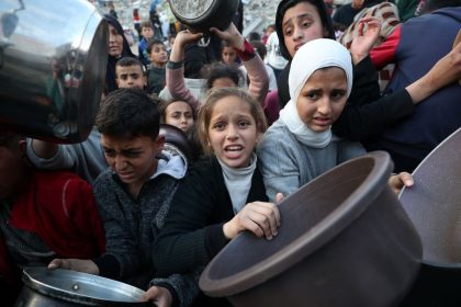 Palestinians wait in line to receive hot food, at Jabalya refugee camp on March 4, 2025.