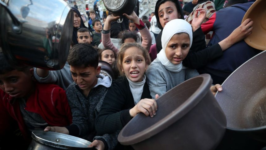 Palestinians wait in line to receive hot food, at Jabalya refugee camp on March 4, 2025.