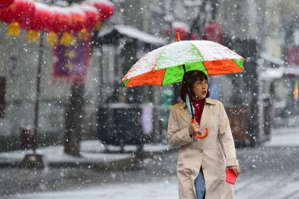 A tourist walks in snow at Qingzhou Ancient Town in Shandong province, China on March 2, 2025.