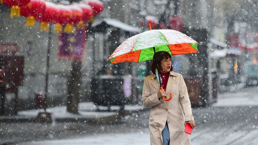 A tourist walks in snow at Qingzhou Ancient Town in Shandong province, China on March 2, 2025.