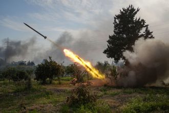 Syrian Army forces fire a missile while battling fighters linked to Syria's ousted president Bashar al-Assad in Latakia, Syria, on Friday.