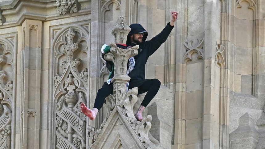 A protestor has climbed several meters up the Elizabeth Tower, commonly known as "Big Ben," and stood barefoot on a ledge holding a Palestinian flag.