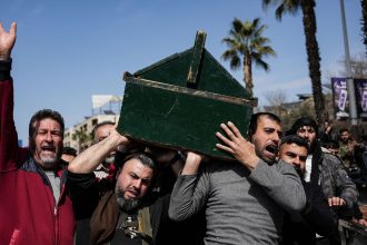 Syrian fighters and civilians carry the coffin of a member of the Syrian security forces during his funeral in Hama province, on March 9, 2025, after he and 11 other colleagues were killed in an ambush by groups loyal to the ousted President Bashar al-Assad in Latakia.